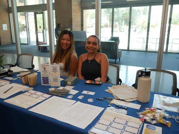 Students assisting with sign ins and promoting community achievements (with boba)