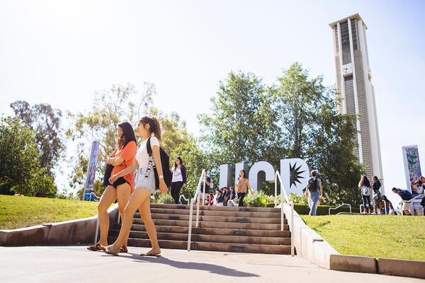 Students walking by UC Riverside's Bell Tower